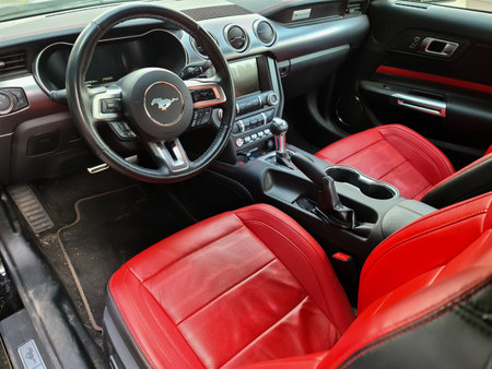Kiel, Germany, 03. September 2022: Side view of steering wheel of 2018 Ford Mustang model sports car with red leather seatsのeditorial素材