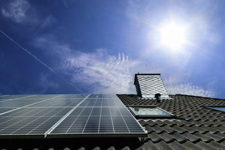 Solar panels producing clean energy on a roof of a residential houseの写真素材