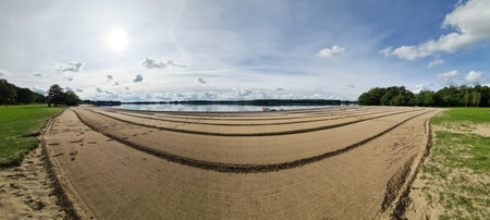 A beach at a lake with a strange pattern in the sandの写真素材