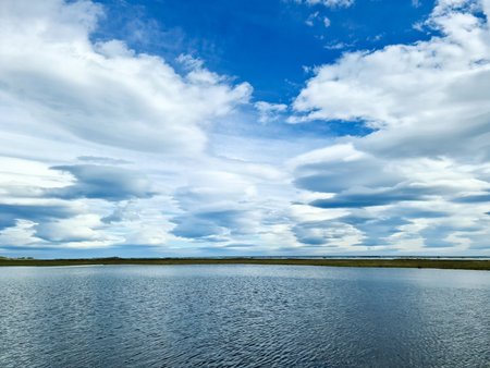 View of a beautiful lake with spectacular clouds and mountains in the Icelandic landscapeの写真素材