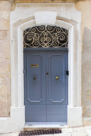 A weathered wooden door leading to a flat in Malta's historic alleywaysの写真素材