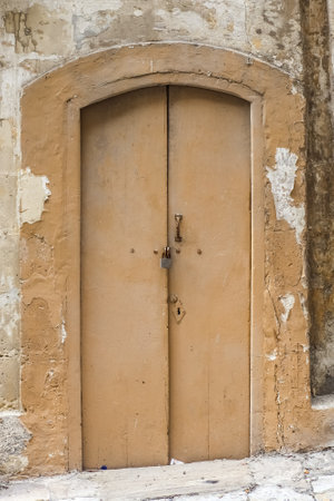 An old door brown to a flat in the alleyways of Maltas historic old townsの写真素材