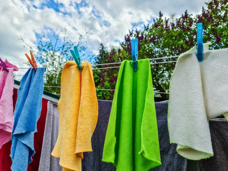 Clean colorful towels drying on a clothesline in a gardenの写真素材