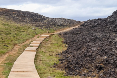 Elevated wooden path traversing a geothermal area, providing safe passage amidst the rugged terrain of leirhnjÃºkur volcanoの写真素材