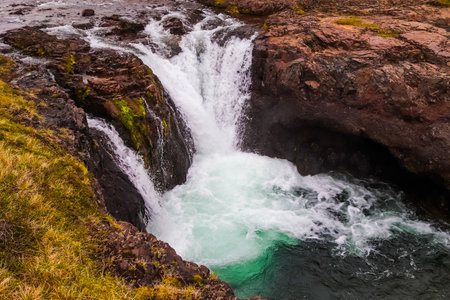 Waterfall cascades into a pool of waterの写真素材