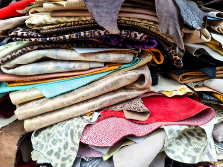 Close-up of a large stack of colorful leather and fabrics, showcasing a variety of textures and patterns, ideal for fashion, upholstery, or design projectsの写真素材