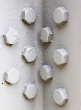 Close-up of screws fastening metal surface, showcasing industrial strength and construction