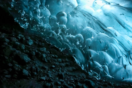 Smooth, undulating blue ice formations create a mesmerizing spectacle within an ice cave in...
