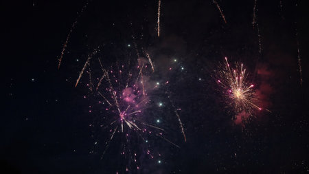 Colorful fireworks exploding in the dark night sky, creating a spectacular display of light and...