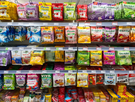 Kiel, Germany - 24. November 2025: Assortment of Ricola and Em-eukal cough drops, throat lozenges, and herbal candies displayed on a German supermarket shelfのeditorial素材