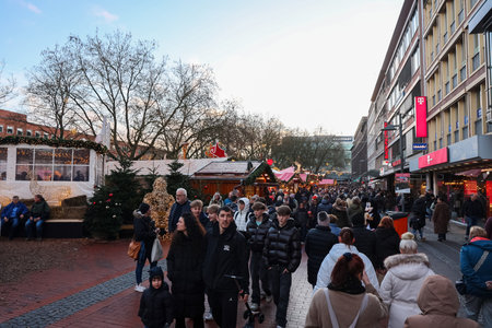 Kiel, Germany - 13. December 2025: People enjoying a festive Christmas market with decorated stalls and shopping streetのeditorial素材