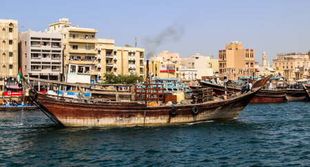 Dubai, Arab Emirates - 26. September 2025: Traditional wooden dhow boat is sailing on Dubai Creek...