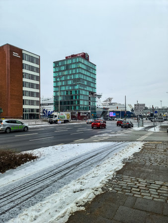 Kiel, Germany - 12. January 2026: City street in Kiel showing buildings, moving cars, and large ferries in the harborのeditorial素材