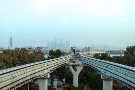 Dubai, United Arab Emirates - 24. September 2024: Monorail train approaching on elevated tracks with...