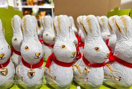 Kiel, Germany - 07. February 2026: Chocolate bunnies wrapped in white foil with red scarves for sale during Easterのeditorial素材