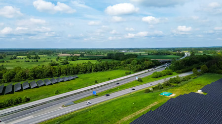 Renewable energy solar panels generating clean power alongside a busy highway in Germany