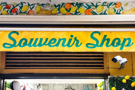 Sorrento, Italy - 6. March 2026: Yellow light-up souvenir shop awning with painted lemon relief and security camera outside