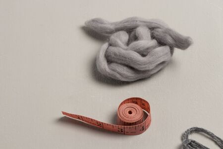 Coral metric tape with gray wool on gray backgroundの写真素材
