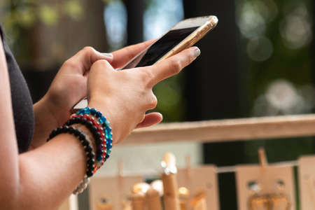 Woman hands with cell phone sending text message at a jewelry fair