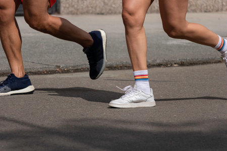Legs of people running in city race with white shoes and colored tights