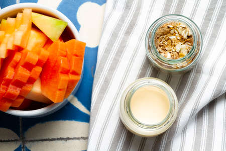 Plate of tropical fruits with portion of milk and cereal for the American breakfast of a hotelの写真素材