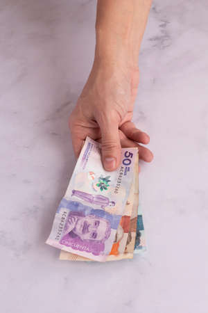 hands holding colombian moneyの写真素材