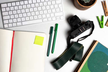 Photography student work table with pencils, notebook, camera and a white keyboardの写真素材