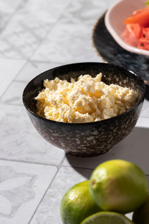 Cottage cheese in a bowl with lime and watermelon on the table