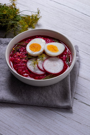 Purple Power: Radish Soup and Egg A side view of a bowl of hearty radish and egg soup, steaming on a wooden table.の写真素材