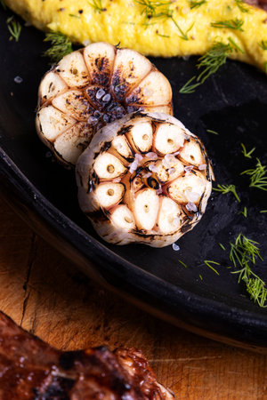 Delicious, rustic-yet-elegant presentation of a pork chop and rich yellow mashed potatoes. Roasted garlic adds an aromatic touch, perfect for high-end recipe cards and editorial food spreads.の写真素材
