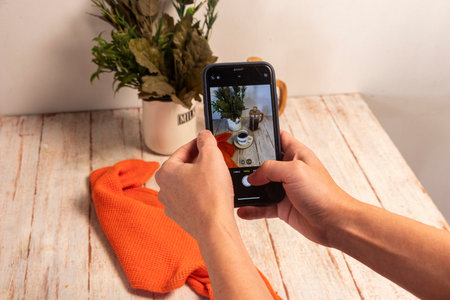 Capturing the perfect flat lay for a coffee brand's social media. A smartphone is used to photograph a setup with earth tones and a wooden texture. Focus on mobile photography trends.の写真素材