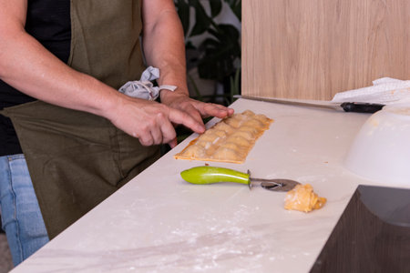 The delicate process of making homemade ravioli by hand, highlighting the freshness and quality ingredients. Perfect for promoting healthy, traditional family cooking.の写真素材