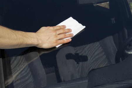Man cleaning windscreen on a sunny day 