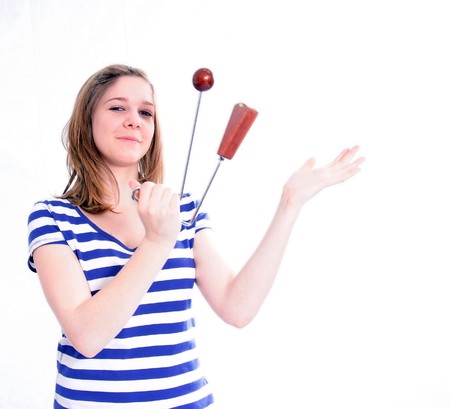Studio Shot of a beautiful young woman in blue jeans and blue-white t-shirt playing percussion, isolated on white backgroundの写真素材