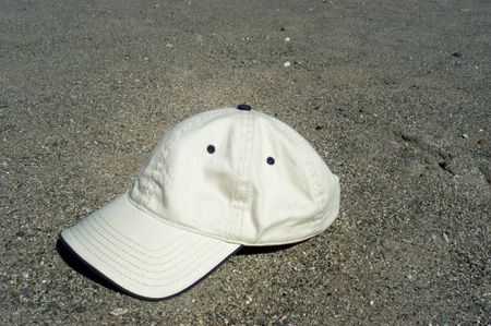 Baseball cap laying on the beachの写真素材