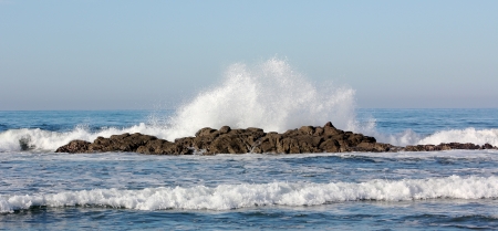 Waves crashing on a rocky reef in the Pacific Ocean, in the early morning の写真素材