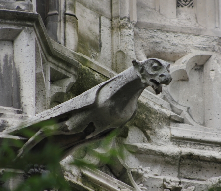 A lone, outstretched stone gargoyle appears to be soaring straight out from Notre Dame Cathedral, Paris, Franceの写真素材