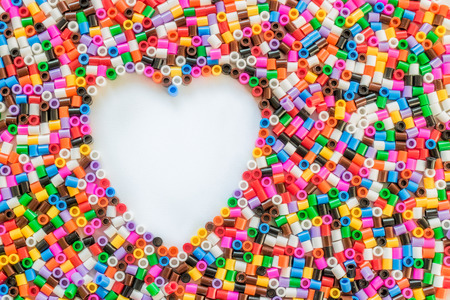 White heart made from red green yellow beadsの写真素材