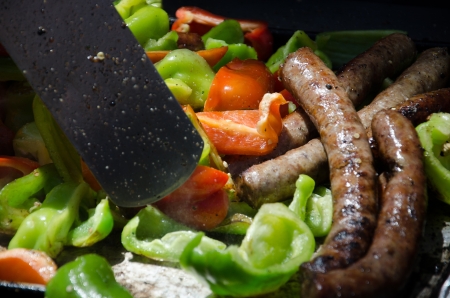 Polish sausages are grilled with red and green bell peppers on a large outdoor grill at Old Colorado City Teritory Days, near Colorado Springs, Colorado.の写真素材