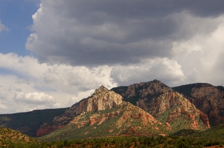 Storm couds move in to mix with sunlight to create dramatic lighting on the landscape near Sedona, Arizona の写真素材
