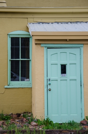 Flat light from an overcast sky provides a nice image of a light green door on an old tan building in downtown Colorado Springs, Colorado のeditorial素材