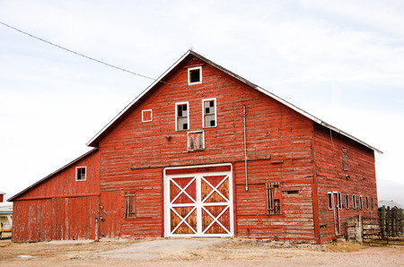 A classic red barn with white trim in good condition on the Colorado plains in afternoon lightのeditorial素材