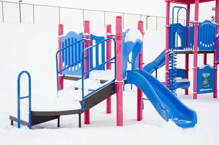 Neighborhood playground equipment after snow storm leaves fresh white snow on the playground.の写真素材