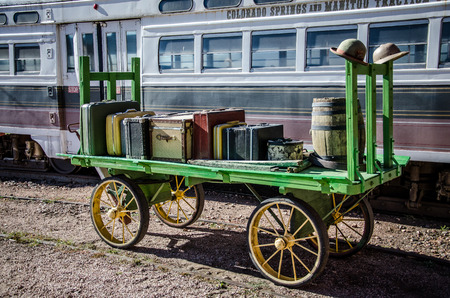 An antique green wagon with vintage luggage in front of restored trolley car at Pikes Peak Trolley Museum on Colorado Springs, Colorado の写真素材