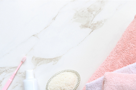 Pink and white bathroom essentials on white marble copy space.の写真素材