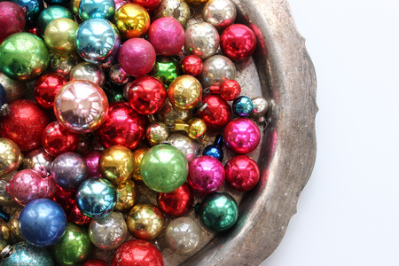 Multi-colored vintage ornaments on silver platter. Copy space.の写真素材