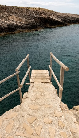 Wooden dock at the cliff over waterの写真素材