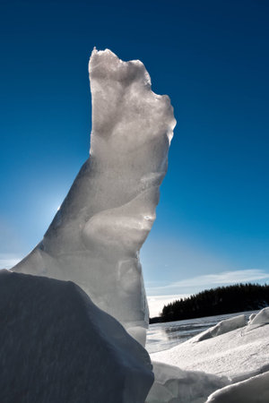 Vertical formation of cracked ice with backlight at a sunny Finnish lakeside in the springの写真素材