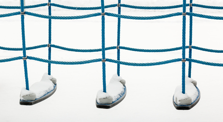 Snowy climbing rope equipment with white background at a playground in winterの写真素材
