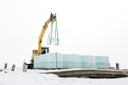 Excavator lifting large ice cubeの写真素材